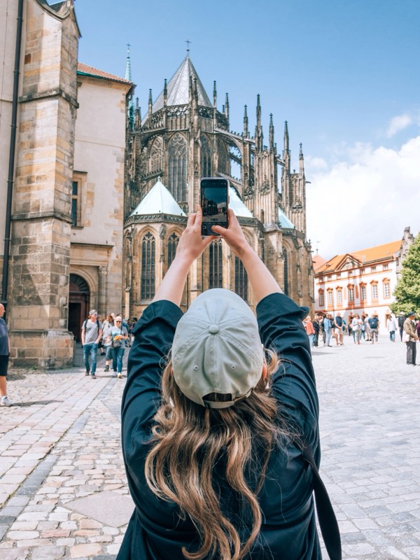 A traveller at a vantage point above Rome, framing the dome on her phone